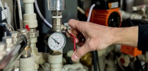 Heating engineer fixing modern heating system in boiler room. Automatic control unit. Engineering systems for home
