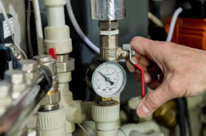 Heating engineer fixing modern heating system in boiler room. Automatic control unit. Engineering systems for home