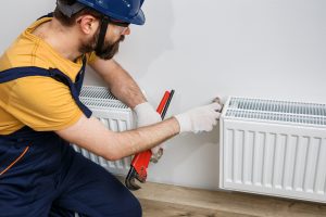 man fixing radiator